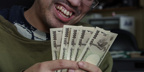 複数枚の1万円札を数えて笑う男性