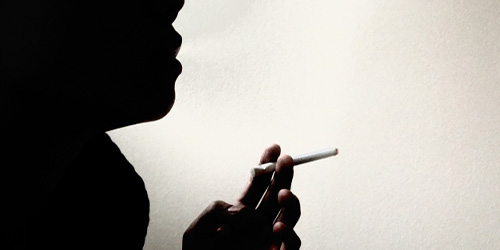 タバコを吸う女性のシルエット