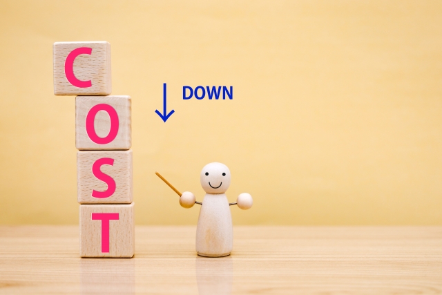 「コストダウン」を指さす人形