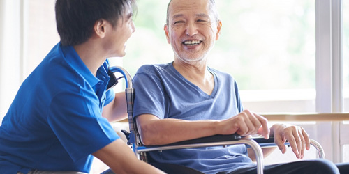 車椅子の男性と笑顔で話す人