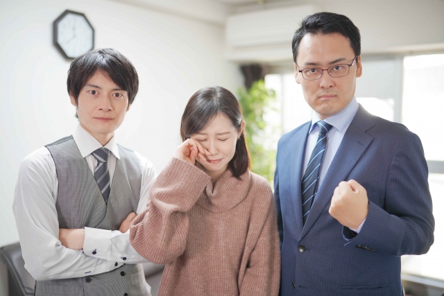 二人の男性の間で泣く一人の女性
